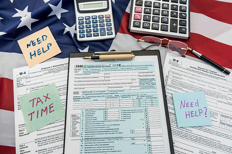 finance document 1040 tax form with pen and calculator on flag of USA. Deadline